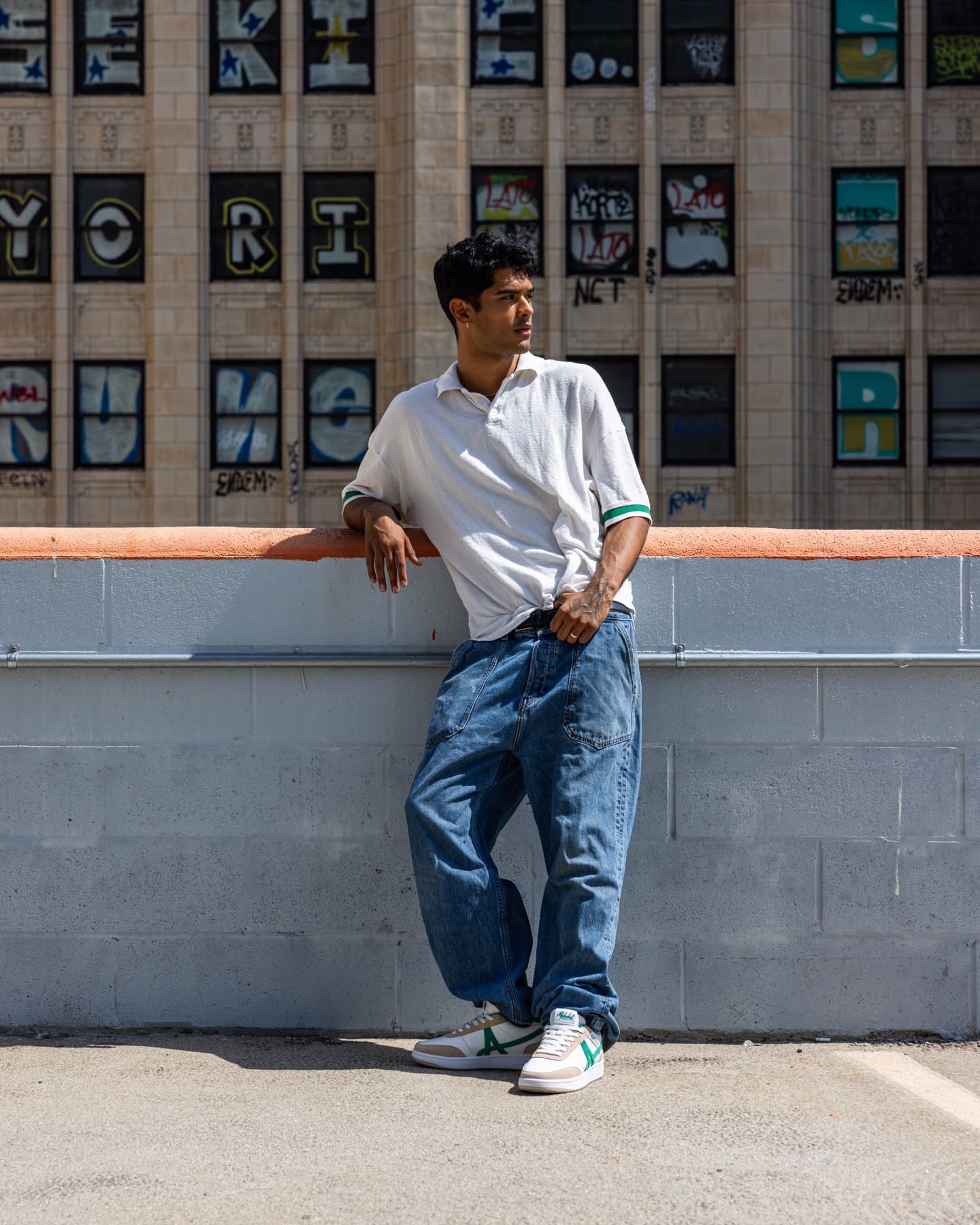 Model wearing green and beige sneakers on a rooftop