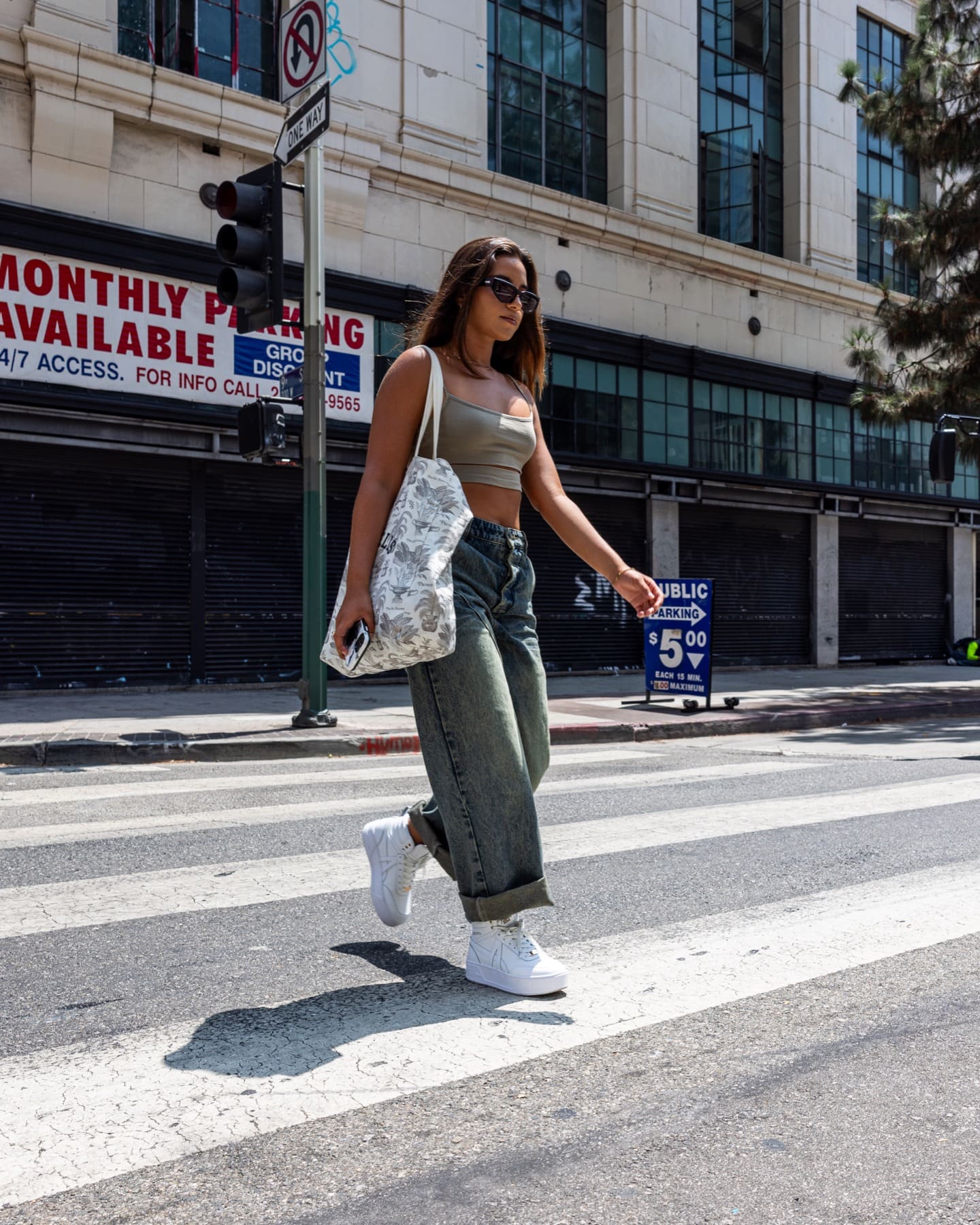 Model crossing a street in white sneakers